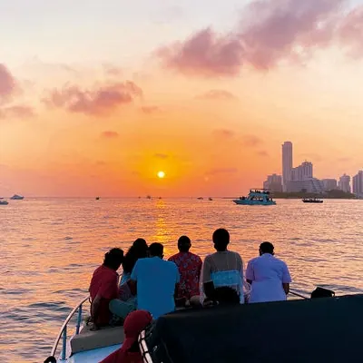 Viajeros observando el atardecer desde la embarcación